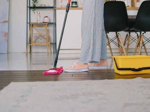 Vloer dweilen met een mop en emmer